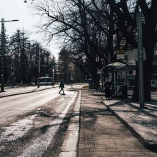 Pirkankatu Metson bussipysäkiltä kuvattuna kohti Pyynikintoria. Jalankulkija ja keskellä rata sekä yhteiskäyttöpylväitä. Kuva Wille Nyyssönen.